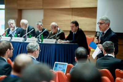 Panel of five men plus one other speaking to audience