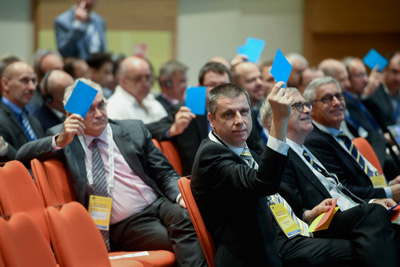 Delegates holding up blue rectangles of paper